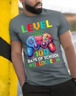 Level 100 Days of School Unlocked T-Shirt - model leaning on yellow-black pole, wearing Gray T-shirt, hand in pocket