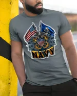 Proud U.S. Navy Crest and Flags Tee - model leaning on yellow-black pole, wearing Gray T-shirt, hand in pocket
