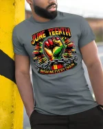 Juneteenth Breaking Every Chain Tee - model leaning on yellow-black pole, wearing Gray T-shirt, hand in pocket