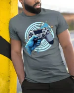 Epic Gamer Controller T-Shirt - model leaning on yellow-black pole, wearing Gray T-shirt, hand in pocket