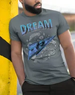 Dream Big Money Plane Tee - model leaning on yellow-black pole, wearing Gray T-shirt, hand in pocket