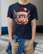 Cute Highland Cow Christmas Graphic T Shirt Cozy Holiday Vibes Tee - model wearing navy tee with hands in pockets