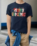 Merry Christmas Festive Typography Graphic T Shirt Cozy Holiday Tee - model wearing navy tee with hands in pockets