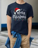 Merry Christmas Script With Santa Hat Graphic T Shirt Festive Tee - model wearing navy tee with hands in pockets