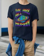 We Are All Human Rainbow Planet Equality Tee Tshirt - model wearing navy tee with hands in pockets
