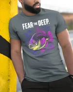 Fear The Deep Neon Fish Graphic Tee Tshirt - model wearing grey tee, leaning on column