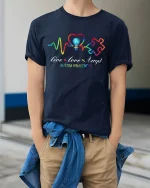 Live Love Accept Autism Awareness T Shirt With Colorful Heartbeat - model wearing navy tee with hands in pockets