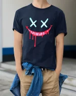 Creepy Dripping Smile Face Dark Humor Graphic Tshirt - model wearing navy tee with hands in pockets