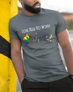 Love Need No Words Autism Puzzle Heartbeat Graphic T Shirt - model wearing grey tee, leaning on column