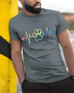 Rainbow Heartbeat Paw Print Love Graphic T Shirt - model wearing grey tee, leaning on column