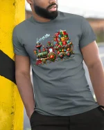 Christmas Gift Train Tee with Colorful Holiday Locomotive Art - model wearing grey tee, leaning on column