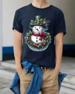 Christmas Snowman T Shirt Cozy Holiday Wreath Art Graphic Tee - model wearing navy tee with hands in pockets