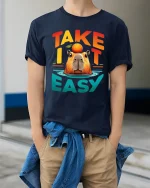 Take It Easy Capybara Relaxed Funny Graphic T Shirt Design - model wearing navy tee with hands in pockets
