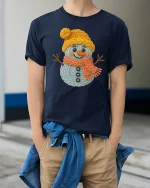 Cute Knitted Snowman Winter Art T Shirt With Cozy Joy - model wearing navy tee with hands in pockets