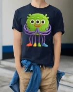 Cute Green Alien Monster Cartoon Art T Shirt Funny Graphic Tee - model wearing navy tee with hands in pockets