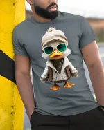 Cool Explorer Duck Cartoon Tee Fun Adventure Graphic Style - model wearing grey tee, leaning on column