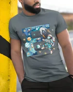 Space Astronaut Letter F Art Tee Cosmic Cartoon Galaxy Style - model wearing grey tee, leaning on column