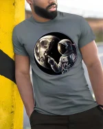Astronaut Moon Space Graphic T-Shirt Cosmic Explorer Tee - model wearing grey tee, leaning on column