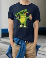 Strike Frog Fishing Funny Fisherman Cartoon T-Shirt - model wearing navy tee with hands in pockets