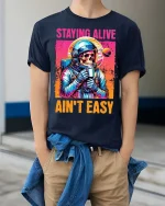 Staying Alive Ain’t Easy Funny Astronaut Skull T-Shirt - model wearing navy tee with hands in pockets