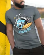 Stoopid Dog Surfing Shark Funny Surf Graphic T-Shirt - model wearing grey tee, leaning on column