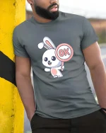Cute Bunny OK Sign Cartoon Graphic T-Shirt Funny Kawaii Tee - model wearing grey tee, leaning on column
