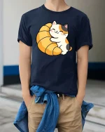 Cute Cat Croissant Graphic T-Shirt Kawaii Food Lover Tee - model wearing navy tee with hands in pockets