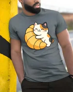 Cute Cat Croissant Graphic T-Shirt Kawaii Food Lover Tee - model wearing grey tee, leaning on column