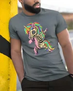 Skeleton Unicorn T-Shirt Funny Rainbow Dabbing Tee - model wearing grey tee, leaning on column