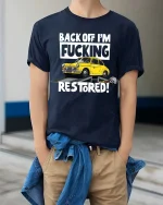 Back Off I’m Restoring Classic Car Mechanic Humor Tshirt - model wearing navy tee with hands in pockets
