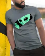 Peeking Alien Funny UFO Extraterrestrial Graphic T Shirt - model wearing grey tee, leaning on column