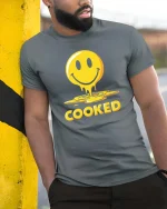 Funny Melted Smile Cooked Tshirt Drip Emoji Graphic Tee - model wearing grey tee, leaning on column