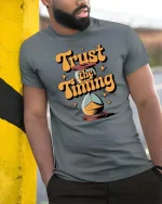 Trust The Timing Motivational Quote Graphic Tshirt Style - model wearing grey tee, leaning on column