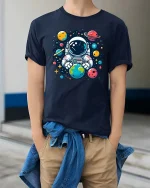 Cute Astronaut Holding Earth Space Cartoon Graphic Tshirt - model wearing navy tee with hands in pockets