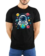 Cute Astronaut Holding Earth Space Cartoon Graphic Tshirt - model wearing black tee with hands behind back