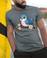 Cute Blue Bird On Flower Branch Cartoon Graphic Tshirt - model wearing grey tee, leaning on column